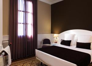 卡尔德斯德马拉维亚1881 Hotel Balneario Vichy Catalan的卧室设有一张白色大床和一扇窗户。