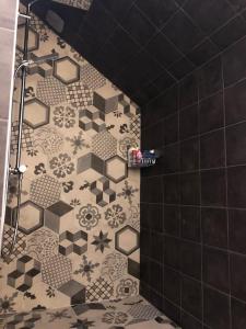 VolnayLa Maison Des Vignes *****的浴室设有黑色和白色瓷砖淋浴。