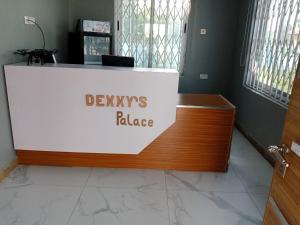 KoforiduaDexxy's Palace Hotel的一张写有读恶魔宫殿的标语的桌子