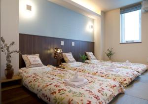 札幌Miidokoro House Hotel的一间卧室配有两张带毛巾的床