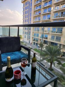 拉斯阿尔卡麦Summer By The Sea Ultra Luxe 1 bedroom Apartment with a private beach - Al Marjan Island的餐桌上一杯葡萄酒,享有建筑的景色