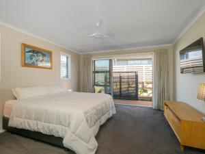 怀蒂昂格Relax on Roseberry - Whitianga Holiday Home的一间卧室设有一张大床和一个窗户。