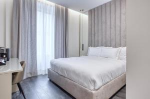 米兰Le Suite del Corso The Smart Boutique Aparthotel By OSPITAMI的一间卧室设有一张床和一个大窗户