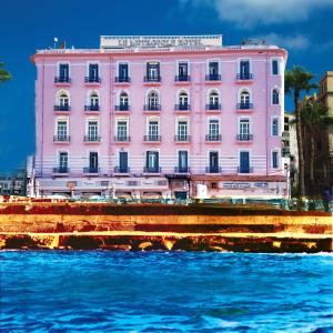 亚历山大Le Metropole Luxury Heritage Hotel Since 1902 by Paradise Inn Group的水岸上的粉红色建筑