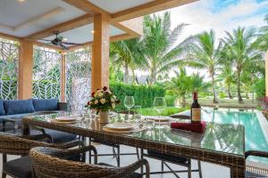 象岛Lazure Pool Villa - Koh Chang的用餐室配有带1瓶葡萄酒的桌子