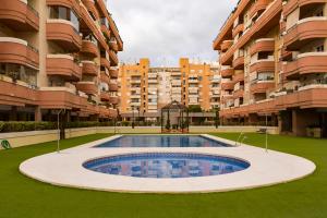 马拉加Apartamento Málaga Jalón的一座大型公寓楼前的空游泳池