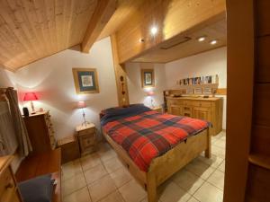 托讷猫头鹰小木屋的一间带一张床的卧室,位于带木制天花板的房间内