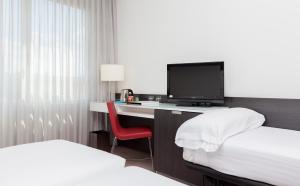 马德里奥克斯斐瑞拉酒店的酒店客房设有一张桌子、一台电视和一张床