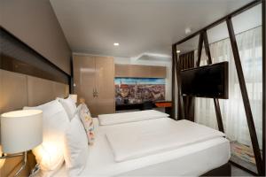 慕尼黑慕尼黑柯雷思公寓式酒店的卧室配有白色的床和平面电视。