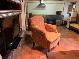 费莱乔萨El Corral de Baxo的带壁炉的客厅内的橙色椅子