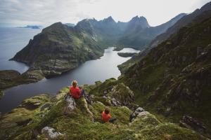 索尔瓦根罗弗敦行星基地营旅馆的两人坐在山边,俯瞰湖泊