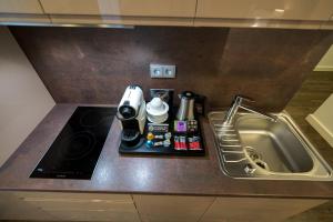 慕尼黑慕尼黑柯雷思公寓式酒店的厨房柜台配有咖啡壶和水槽
