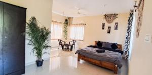 AravankāduGhar - Homestay, Where Family Lives Together的一间卧室配有一张床和盆栽植物