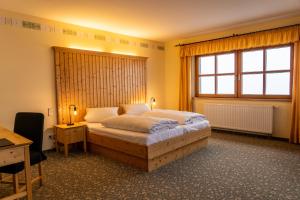 奥泊维森塔尔Fichtelberghaus的一间卧室配有一张床、一张书桌和一个窗户。