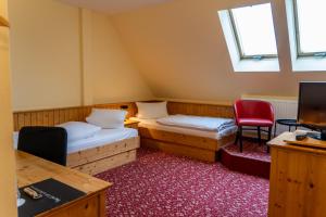奥泊维森塔尔Fichtelberghaus的一间设有两张床和红色椅子的房间
