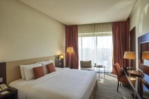 多哈萨菲尔多哈酒店的一间酒店客房,设有一张大床和一个大窗户