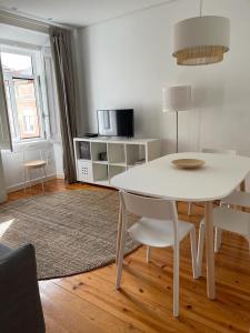 里斯本LX Factory Apartment 1的客厅配有白色的桌椅