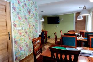 利布韦尔达矿泉村Vila Tess的一间带桌椅和花卉墙面的用餐室