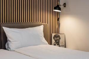 柏林stadtRaum-berlin apartments的一张带枕头的床和一张男人的照片