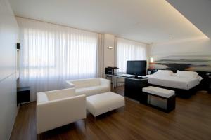 马德里阿瑟尔巴拉哈斯的客厅配有白色家具、一张床和电视