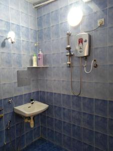 怡保QQ Homestay的蓝色瓷砖浴室设有水槽和淋浴