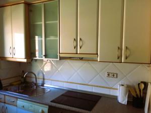 萨拉戈萨Antequera3的厨房配有白色橱柜和水槽