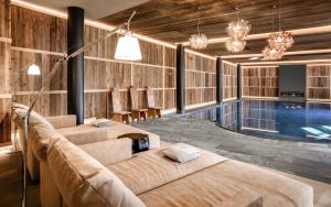奥蒂塞伊Gardena Grödnerhof - Hotel & Spa的一个带两张床的泳池间和一个游泳池