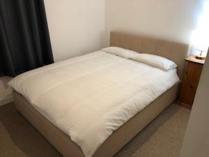 ScallowayCosy flat, Scalloway的一张带白色床单和枕头的床