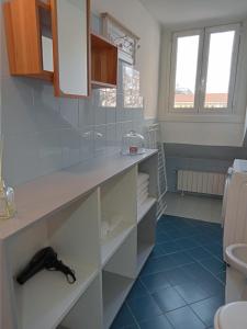 都灵La Mole apartment的浴室铺有蓝色瓷砖地板,配有白色橱柜。