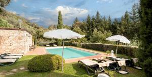 卢卡Casetta di Butia, Appartamento Iris的游泳池旁的游泳池配有遮阳伞和椅子