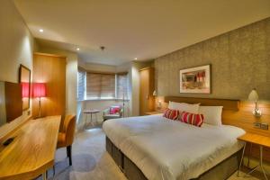伯恩茅斯兰花酒店的酒店客房设有一张大床和一张书桌。