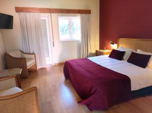 旧阿尔贝加里亚瑞贝罗特尔酒店的一间卧室设有一张大床和一个窗户。