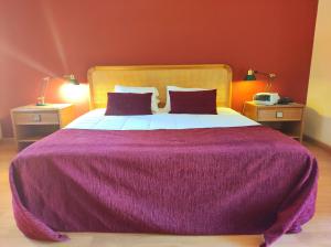 旧阿尔贝加里亚瑞贝罗特尔酒店的一间卧室配有一张大紫色床和两盏灯
