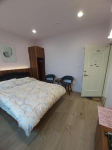 三芝乡旅途中海邊民宿的卧室配有一张床和一张桌子及椅子