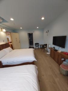 三芝乡旅途中海邊民宿的酒店客房设有两张床和一台平面电视。
