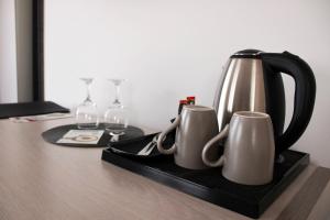Čitluk布罗尼奥酒店的茶壶和桌子上的盘子上的两个杯子