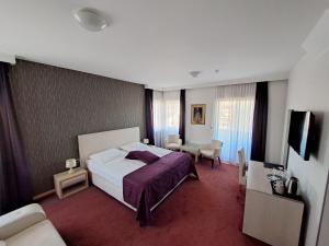 Čitluk布罗尼奥酒店的酒店客房配有一张床铺和一张桌子。