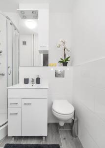 华沙Central Apartments Grzybowska的白色的浴室设有卫生间和水槽。