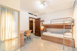 塞维利亚Green- Apartments Las Setas的一间卧室配有双层床、书桌和镜子