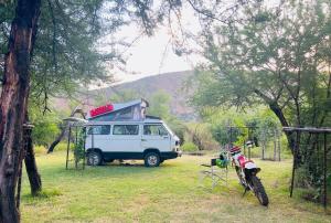 SandvlakteBaviaanskloof Laaste Kamp - Wild Bush Camping的一辆挂在顶部的露营车停在田野里