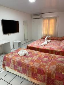 福塔莱萨Hotel Pousada Villa Marina的酒店客房设有两张床和一台平面电视。