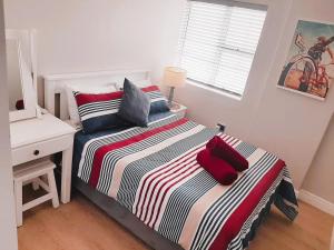 莫塞尔湾501 Beach Club的一间卧室配有一张带书桌的床和一张四柱床。