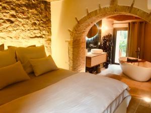 滨海萨纳里Bastide Sainte Trinide的一间卧室设有一张大床和一个浴缸