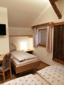 米特西尔Hintergugg的一间卧室设有两张床、一张桌子和一个窗口。