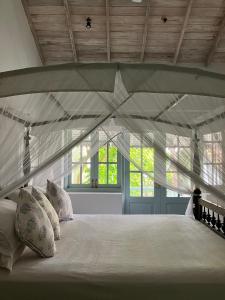 哈巴拉杜瓦萨穆德拉海滨别墅的带窗户的客房内的白色床和枕头