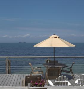 蒙托克蒙托克太阳与声音酒店的一张桌子和椅子,配有雨伞和大海