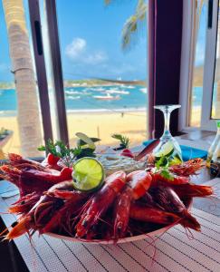 达喀尔La Cabane du Pêcheur Atlantic Evasion的一张桌子上放着一盘龙虾,享有海滩美景