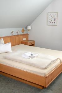 Neuenkirchen-Vörden克鲁斯祖姆霍罗托酒店的一间卧室配有一张带白色床单的大床