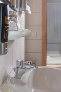 Neuenkirchen-Vörden克鲁斯祖姆霍罗托酒店的浴室水槽设有水龙头和镜子