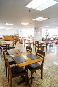马塞约Marinas Maceió Hotel的一间食堂,在房间内配有木桌和椅子